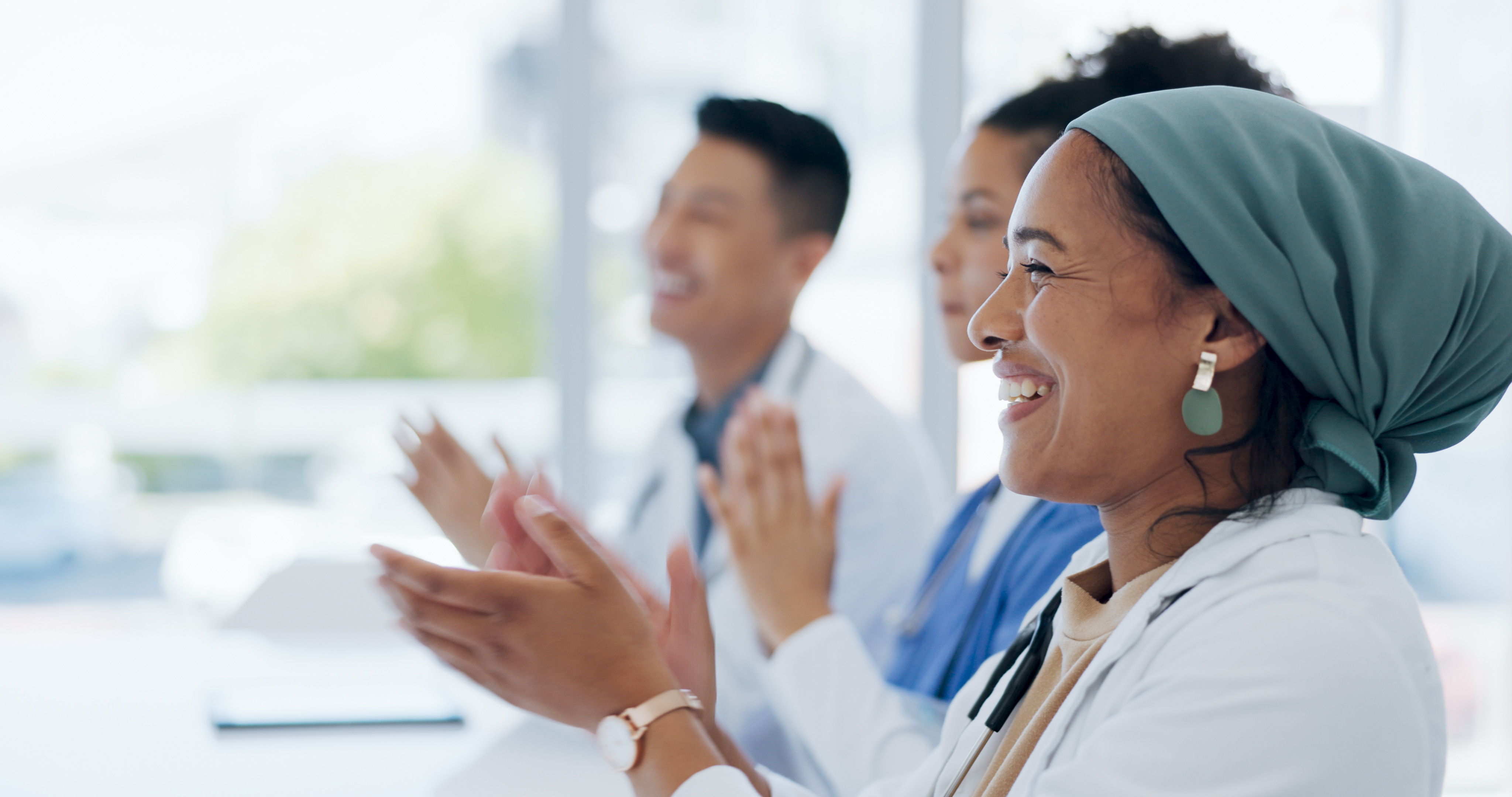 Group of clinicians smiling and clapping